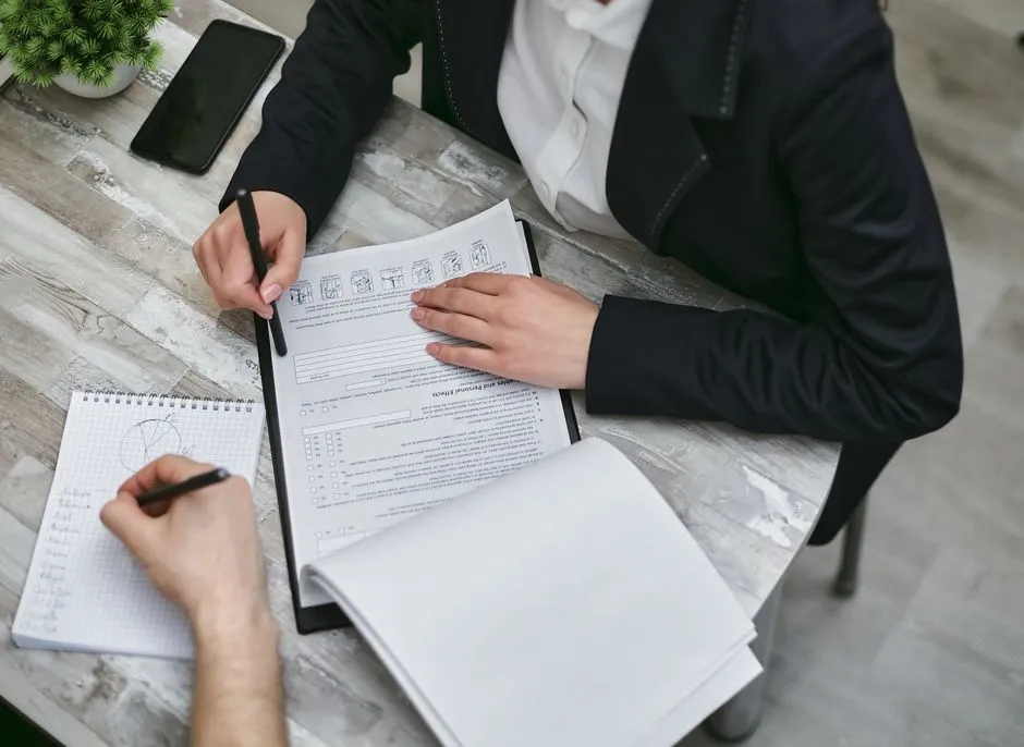 Two people at a desk sorting through paperwork, illustrative of gathering documents for a housing assistance application