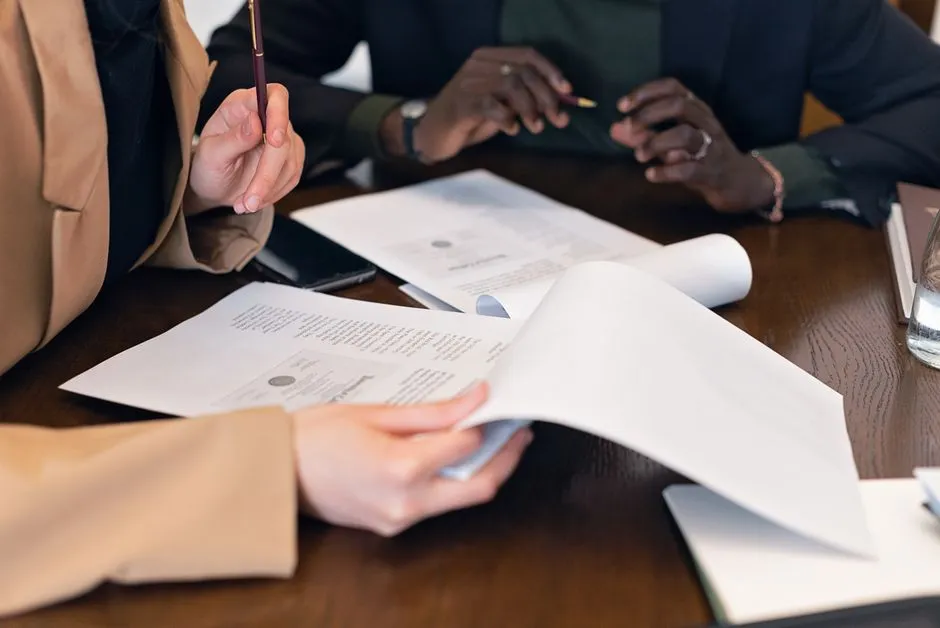 Two people reviewing paperwork at a desk, illustrating the kind of documentation a rental-assistance application requires